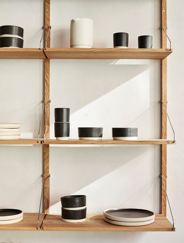 Frama Otto Ceramics displayed on oak shelving system with afternoon light