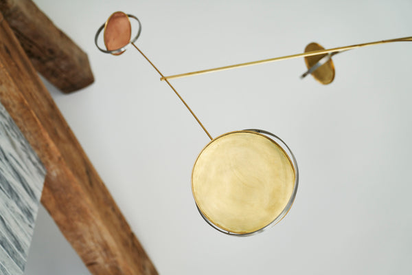 Close-up of the metal mobile by Toke Lauridsen with warm tones of gold and copper, reminiscent of Alexander Calder's works