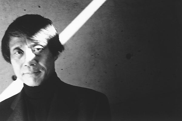 Tadao Ando smiles subtly at the camera as a streak of sunlight crosses his face