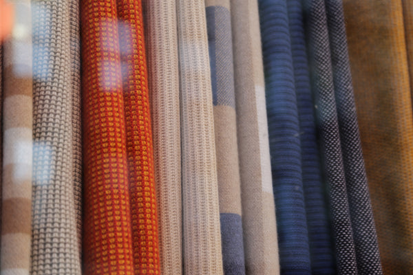 A close up of the colorful throws by Hangai Mountain Textiles from outside of a window