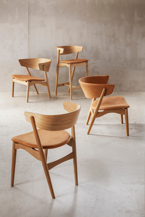 A scenic composition of four Sibast Dining and Lounging Chairs in light oak upholstered in leather seats